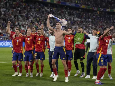 Spain players celebrate at the end of a semifinal match between Spain and France at the Euro 2024 soccer tournament in Munich, Germany, Tuesday, July 9, 2024. Spain won 2-1. (AP Photo/Matthias Schrader)