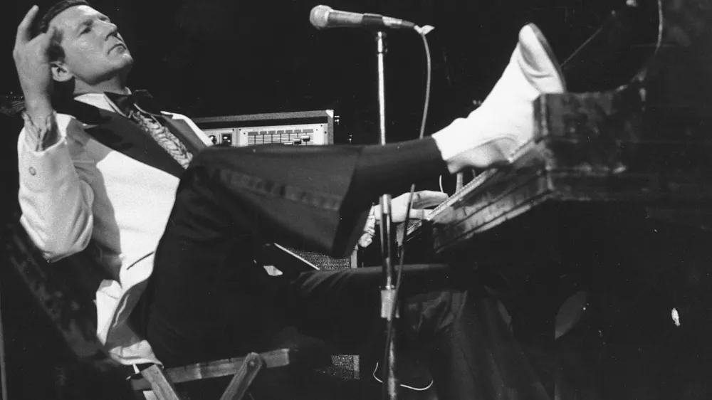 FILE - Jerry Lee Lewis props his foot on the piano as he lays back and acknowledges the applause of fans during the fifth annual Rock 'n' Roll Revival at New York's Madison Square Garden on March 14, 1975. Spokesperson Zach Furman said Lewis died Friday morning, Oct. 28, 2022, at his home in Memphis, Tenn. He was 87. (AP Photo/Rene Perez, File)