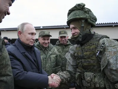 FILE - Russian President Vladimir Putin shakes hands with a soldier as he visits a military training centre of the Western Military District for mobilised reservists as Russian Defense Minister Sergei Shoigu, center, smiles in Ryazan Region, Russia, Thursday, Oct. 20, 2022. The mobilized reservists that Russian President Vladimir Putin visited last week at a firing range southeast of Moscow looked picture-perfect. (Mikhail Klimentyev, Sputnik, Kremlin Pool Photo via AP, File)