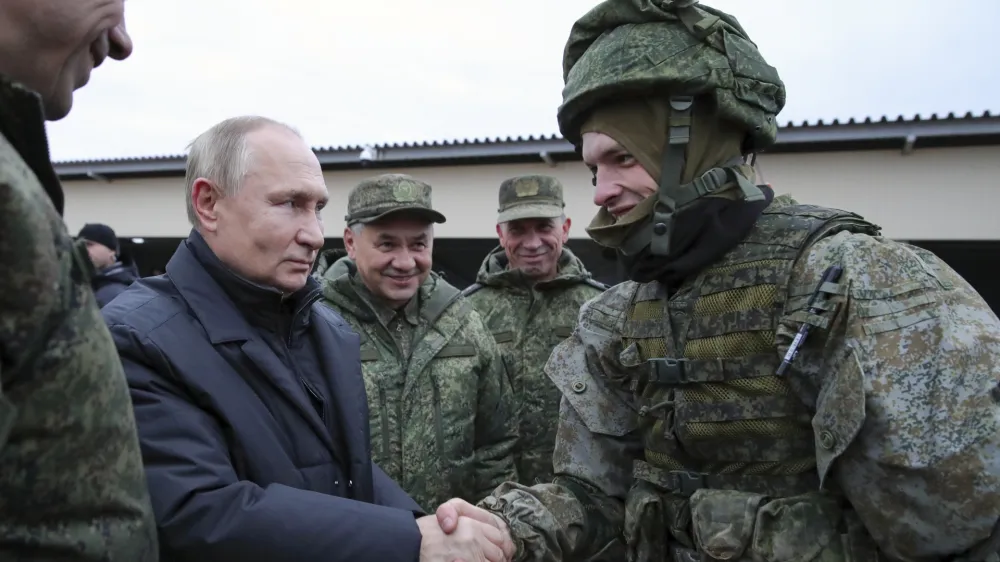 FILE - Russian President Vladimir Putin shakes hands with a soldier as he visits a military training centre of the Western Military District for mobilised reservists as Russian Defense Minister Sergei Shoigu, center, smiles in Ryazan Region, Russia, Thursday, Oct. 20, 2022. The mobilized reservists that Russian President Vladimir Putin visited last week at a firing range southeast of Moscow looked picture-perfect. (Mikhail Klimentyev, Sputnik, Kremlin Pool Photo via AP, File)