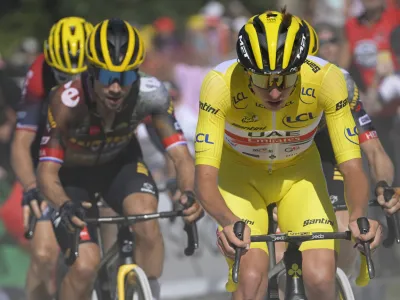 Slovenia's Tadej Pogacar, wearing the overall leader's yellow jersey, and Slovenia's Primoz Roglic climb La Super Planche des Belles Filles,during the seventh stage of the Tour de France cycling race over 176.5 kilometers (109.7 miles) with start Tomblaine and finish in La Super Planche des Belles Filles, France, Friday, July 8, 2022. (Bernard Papon/Pool Photo via AP)