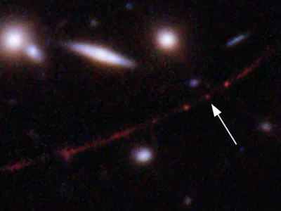 This image made available by NASA on Wednesday, March 30, 2022, shows the star Earendel, indicated by arrow, and the Sunrise Arc galaxy, stretching from lower left to upper right, optically bent due to a massive galaxy cluster between it and the Hubble Space Telescope which captured the light. The mass of the galaxy cluster serves as a magnifying glass, allowing Earendel to be seen. (NASA, ESA, Brian Welch (JHU), Dan Coe (STScI); Image processing: NASA, ESA, Alyssa Pagan (STScI) via AP)