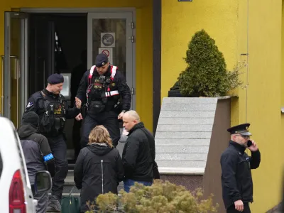 Members of Czech police forces stand in front of a school where a teacher was killed in Prague, Czech Republic, Thursday, March 31, 2022. Police in the Czech capital have arrested a suspect who allegedly killed a teacher at a Prague vocational school with a machete, ofiicials said. The suspect, a student from the school, was arrested after a manhunt that involved hundreds of police officers. (AP Photo/Petr David Josek)