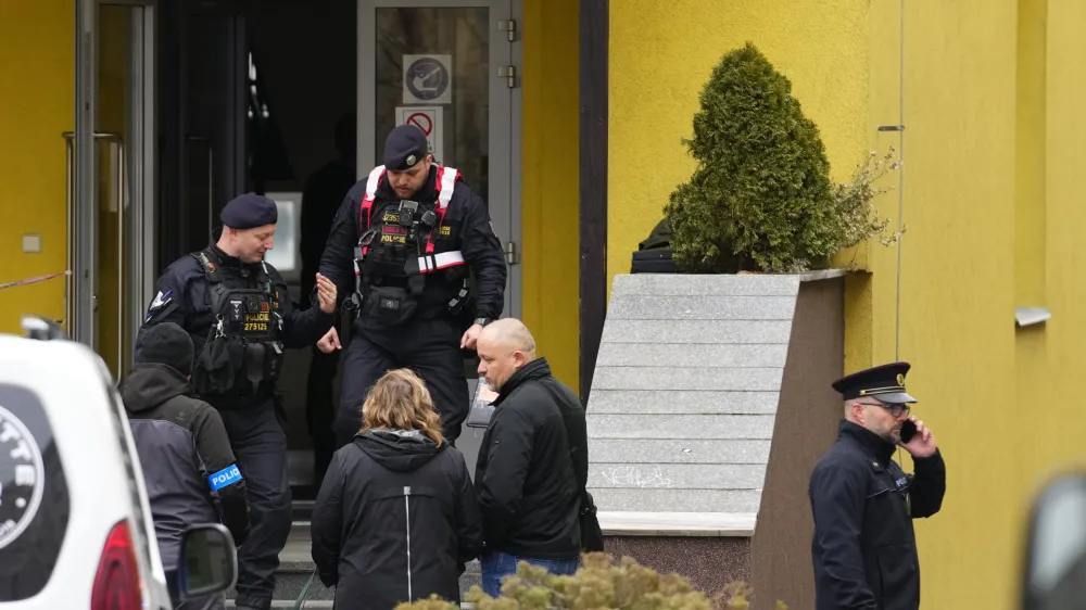 Members of Czech police forces stand in front of a school where a teacher was killed in Prague, Czech Republic, Thursday, March 31, 2022. Police in the Czech capital have arrested a suspect who allegedly killed a teacher at a Prague vocational school with a machete, ofiicials said. The suspect, a student from the school, was arrested after a manhunt that involved hundreds of police officers. (AP Photo/Petr David Josek)