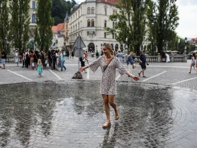 - Mimoidoči v Ljubljani se skušajo ohladiti na Prešernovem trgu, kjer je inštalacija Zmaga Modica ljubljansko lastno vreme.- 10.07.2024. - Vročinski val je zajelSlovenijo s temperaturima preko 30 stopinj.//FOTO: Bojan Velikonja