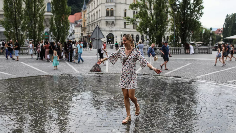 - Mimoidoči v Ljubljani se skušajo ohladiti na Prešernovem trgu, kjer je inštalacija Zmaga Modica ljubljansko lastno vreme.- 10.07.2024. - Vročinski val je zajelSlovenijo s temperaturima preko 30 stopinj.//FOTO: Bojan Velikonja