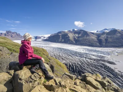 active senior woman, resting above Vatnajokull glacier with Skaftafell glacier tongue in Iceland Vatnajokull glacier with Skaftafell glacier tongue in Iceland