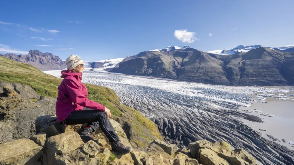 active senior woman, resting above Vatnajokull glacier with Skaftafell glacier tongue in Iceland Vatnajokull glacier with Skaftafell glacier tongue in Iceland