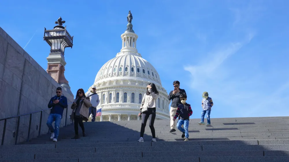 With the U.S Capitol in the background, people walk down steps on Election Day in Washington, Tuesday, Nov. 8, 2022. (AP Photo/Mariam Zuhaib)