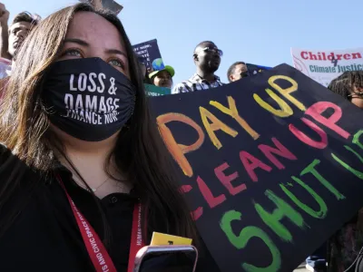 FILE - A demonstrator holds a sign that reads "pay up clean up shut up" during a protest at the COP27 U.N. Climate Summit, Saturday, Nov. 12, 2022, in Sharm el-Sheikh, Egypt. (AP Photo/Peter Dejong, File)