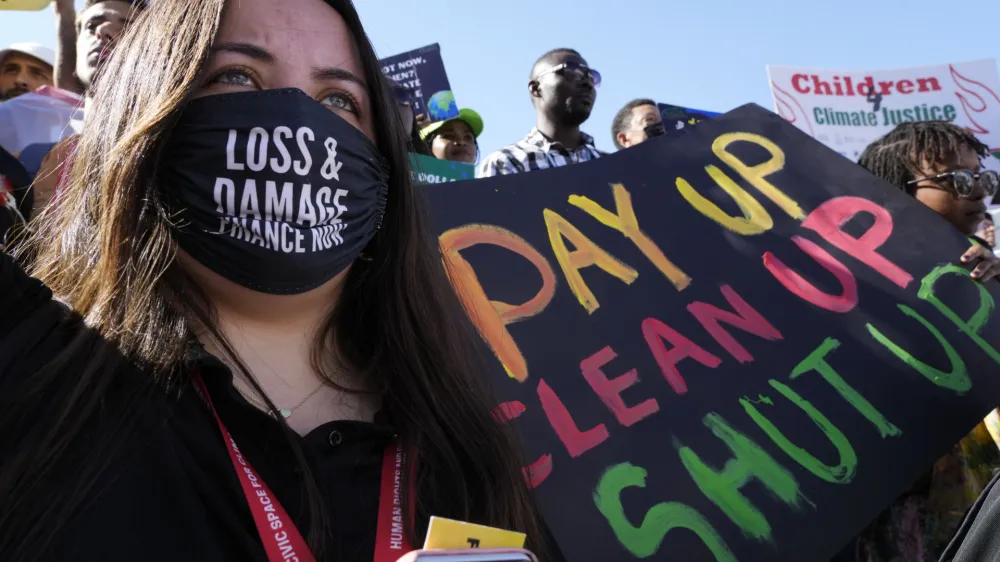 FILE - A demonstrator holds a sign that reads "pay up clean up shut up" during a protest at the COP27 U.N. Climate Summit, Saturday, Nov. 12, 2022, in Sharm el-Sheikh, Egypt. (AP Photo/Peter Dejong, File)