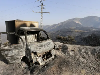 FILE - A charred truck is pictured after a fire near the village of Achlouf, in the Kabyle region, east of Algiers, Friday, Aug. 13, 2021. An Algerian court sentenced 49 people to death Thursday, Nov. 24, 2022 for the brutal mob killing of a painter wrongly suspected of starting devastating wildfires. In fact the man had come to help fight the fires. The 49 people will likely serve life in prison instead because Algeria has a moratorium on executions. (AP Photo/Toufik Doudou, File)