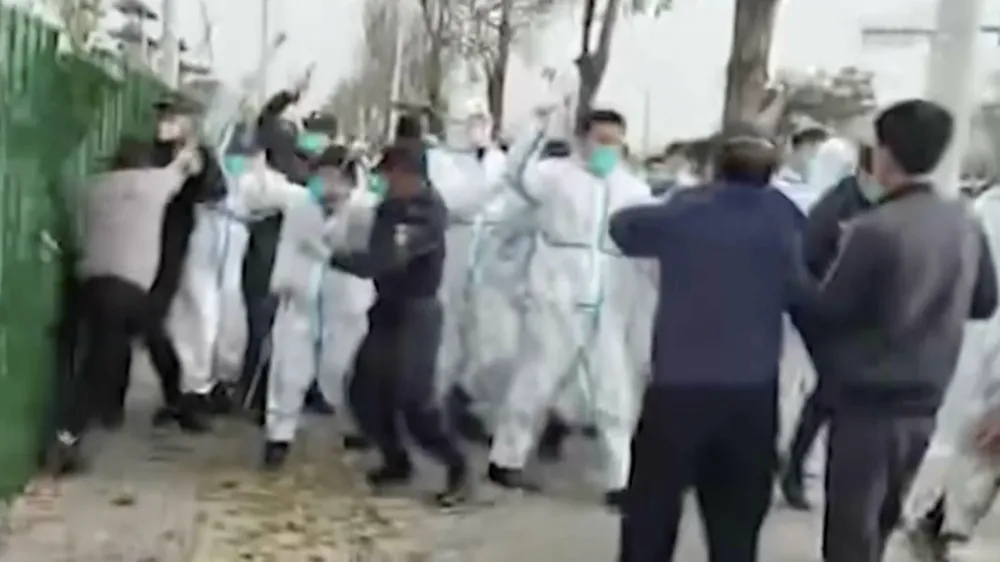 In this photo provided Nov 23, 2022, security personnel in protective clothing attack a man during protest at the factory compound operated by Foxconn Technology Group who runs the world's biggest Apple iPhone factory in Zhengzhou in central China's Henan province. Employees at the world's biggest Apple iPhone factory were beaten and detained in protests over pay amid anti-virus controls, according to witnesses and videos on social media Wednesday, as tensions mount over Chinese efforts to combat a renewed rise in infections. (AP)