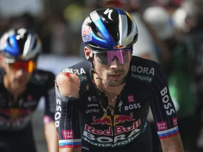 Slovenia's Primoz Roglic crosses the finish line with a shoulder injury after crashing in the last kilometers of the twelfth stage of the Tour de France cycling race over 203.6 kilometers (126.5 miles) with start in Aurillac and finish in Villeneuve-sur-Lot, France, Thursday, July 11, 2024. (AP Photo/Daniel Cole)