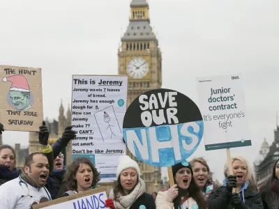 ﻿Junior National Health Service (NHS) doctors wave placards referring to British Conservative Party Secretary of State for Health, Jeremy Hunt, during a protest outside St Thomas Hospital in London, Wednesday, Feb. 10, 2016, backdropped by the Houses of Parliament and Big Ben's clock tower. Thousands of junior doctors have walked off the job in England in a dispute over pay and working conditions. (AP Photo/Frank Augstein)