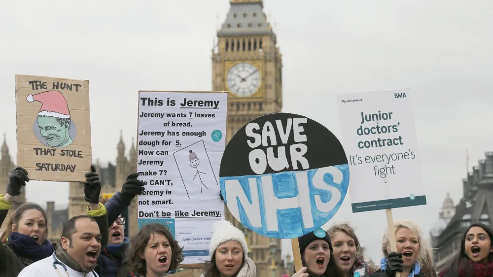 ﻿Junior National Health Service (NHS) doctors wave placards referring to British Conservative Party Secretary of State for Health, Jeremy Hunt, during a protest outside St Thomas Hospital in London, Wednesday, Feb. 10, 2016, backdropped by the Houses of Parliament and Big Ben's clock tower. Thousands of junior doctors have walked off the job in England in a dispute over pay and working conditions. (AP Photo/Frank Augstein)