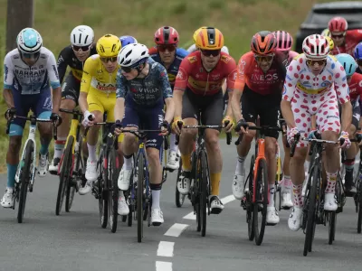 Denmark's Jonas Vingegaard, fourth left, turns back to look at Slovenia's Tadej Pogacar, wearing the overall leader's yellow jersey, during the thirteenth stage of the Tour de France cycling race over 165.3 kilometers (102.7 miles) with start in Agen and finish Pau, France, Friday, July 12, 2024. Right is Norway's Jonas Abrahamsen, the runner-up for the best climber's dotted jersey, which is held by Pogacar. (AP Photo/Jerome Delay)