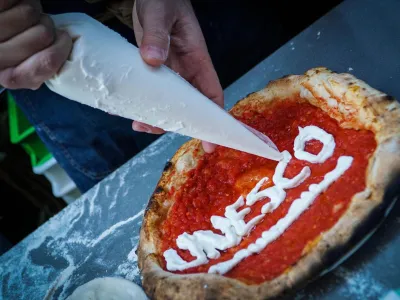 ﻿Neapolitan 'pizzaiuoli' (pizza makers) celebrate UNESCO's recognition by offering slices of pizza to passers-by on the street in Naples, Italy, Thursday, Dec. 7, 2017. UNESCO on Thursday added the art of the Neapolitan pizza maker to its list of "intangible cultural heritage of humanity." (Cesare Abbate /ANSA via AP)