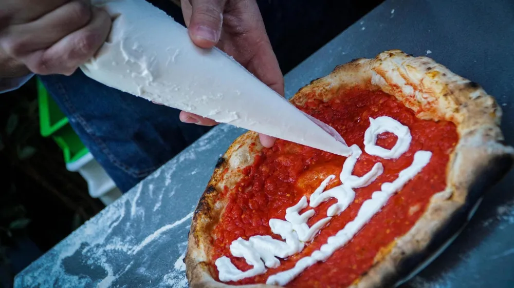 ﻿Neapolitan 'pizzaiuoli' (pizza makers) celebrate UNESCO's recognition by offering slices of pizza to passers-by on the street in Naples, Italy, Thursday, Dec. 7, 2017. UNESCO on Thursday added the art of the Neapolitan pizza maker to its list of "intangible cultural heritage of humanity." (Cesare Abbate /ANSA via AP)