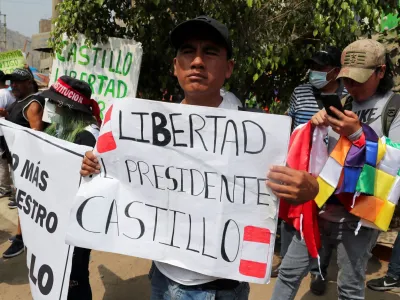 A man holds a placard that reads: "Freedom for President Castillo" as supporters of ousted Peruvian leader Pedro Castillo gather outside the police prison where he is detained, in Lima, December 14, 2022. REUTERS/Sebastian Castaneda