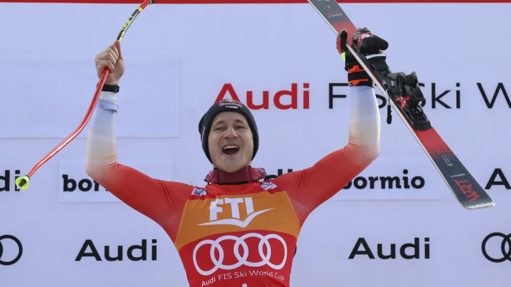 Switzerland's Marco Odermatt celebrates on the podium after winning an alpine ski, men's World Cup Super G race, in Bormio, Italy, Thursday, Dec.29, 2022. (AP Photo/Alessandro Trovati)