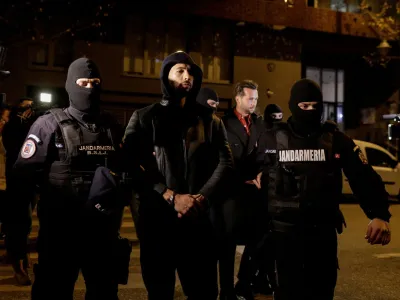 Andrew Tate and Tristan Tate are escorted by police officers outside the headquarters of the Directorate for Investigating Organized Crime and Terrorism in Bucharest (DIICOT) after being detained for 24 hours, in Bucharest, Romania, December 29, 2022. Inquam Photos/Octav Ganea via REUTERS ATTENTION EDITORS - THIS IMAGE WAS PROVIDED BY A THIRD PARTY. ROMANIA OUT. NO COMMERCIAL OR EDITORIAL SALES IN ROMANIA   TPX IMAGES OF THE DAY