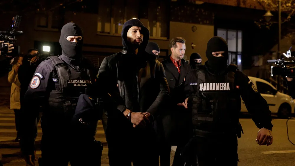 Andrew Tate and Tristan Tate are escorted by police officers outside the headquarters of the Directorate for Investigating Organized Crime and Terrorism in Bucharest (DIICOT) after being detained for 24 hours, in Bucharest, Romania, December 29, 2022. Inquam Photos/Octav Ganea via REUTERS ATTENTION EDITORS - THIS IMAGE WAS PROVIDED BY A THIRD PARTY. ROMANIA OUT. NO COMMERCIAL OR EDITORIAL SALES IN ROMANIA   TPX IMAGES OF THE DAY