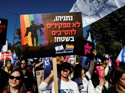 An Israeli holds a sign which says in Hebrew "Netanyahu, we don't abandon LGBTQ's in the field" at a protest outside the Knesset, Israel's parliament, on the day the new right-wing government is sworn in, with Benjamin Netanyahu as Prime Minister, in Jerusalem December 29, 2022. REUTERS/Ammar Awad