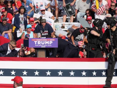 Republican presidential candidate and former U.S. President Donald Trump is assisted by U.S. Secret Service personnel after gunfire rang out during a campaign rally at the Butler Farm Show in Butler, Pennsylvania, U.S., July 13, 2024. REUTERS/Brendan McDermid