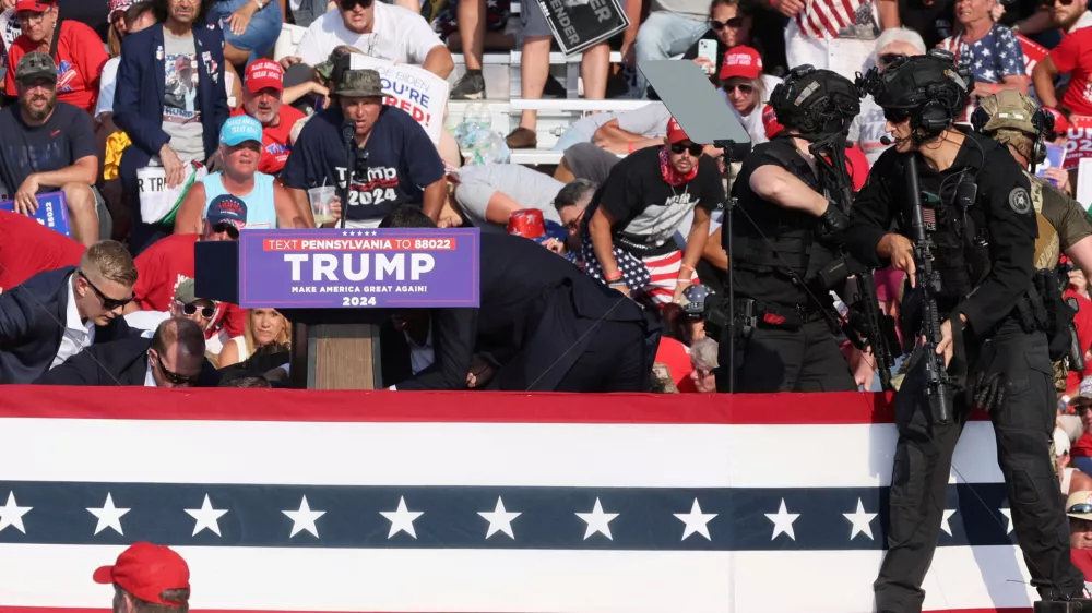 Republican presidential candidate and former U.S. President Donald Trump is assisted by U.S. Secret Service personnel after gunfire rang out during a campaign rally at the Butler Farm Show in Butler, Pennsylvania, U.S., July 13, 2024. REUTERS/Brendan McDermid