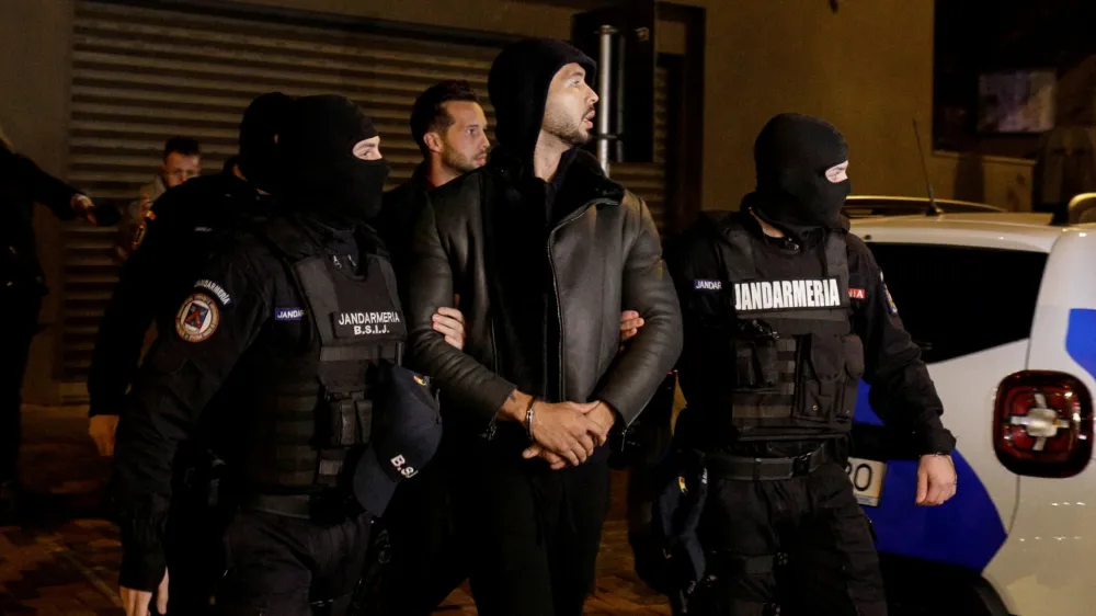 Andrew Tate and Tristan Tate are escorted by police officers outside the headquarters of the Directorate for Investigating Organized Crime and Terrorism in Bucharest (DIICOT) after being detained for 24 hours, in Bucharest, Romania, December 29, 2022. Inquam Photos/Octav Ganea via REUTERS ATTENTION EDITORS - THIS IMAGE WAS PROVIDED BY A THIRD PARTY. ROMANIA OUT. NO COMMERCIAL OR EDITORIAL SALES IN ROMANIA