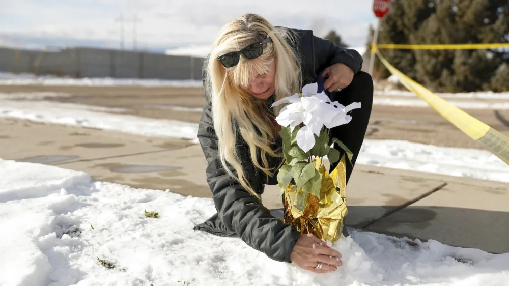 Sharon Huntsman, a member of The Church of Jesus Christ of Latter-day Saints from Cedar City, Utah, leaves flowers outside a home where eight family members were found dead in Enoch, Utah, Thursday, Jan. 5, 2023. Officials said Michael Haight, 42, took his own life after killing his wife, mother-in-law and the couple's five children. (Ben B. Braun/The Deseret News via AP)