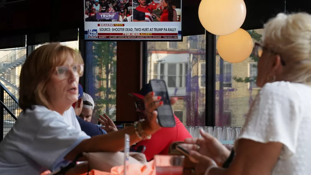 A television in a restaurant shows the news after reports of multiple shots fired and apparent injuries to Republican presidential candidate former U.S. President Donald Trump at his rally in Pennsylvania, outside the site of the 2024 Republican National Convention in Milwaukee, Wisconsin, U.S., July 13, 2024. REUTERS/Brian Snyder