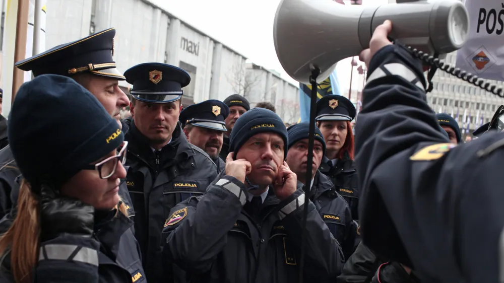 ﻿10.12.2015 - Policijska stavka - Policisti, ki stavkajo že od 18.novembra so se zopet zbrali pred vlado in parlamentom na protestnem shodu, s katerim želijo javnosti in predvsem vladi pokazati, da so enotni in odločeni vztrajati pri uveljavitvi zapisanih zavez, med drugim povečanje plač za 35 odstotkov in izplačilo presežnih ur, hkrati pa opozorili na neurejen status in neustrezno opremo - protestni shod - ///FOTO: Luka Cjuha