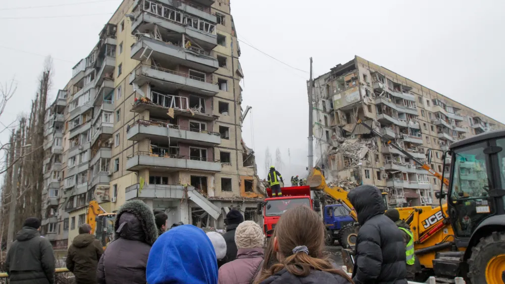 15 January 2023, Ukraine, Dnipro: People watch as rescuers search for survivors at an apartment block hit by Russian rockets during a massive missile attack on Dnipro. Photo: -/Ukrinform/dpa