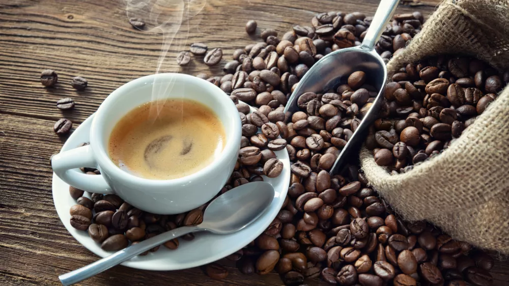 ﻿Cup of espresso with coffee beans, bag, scoop and steam on rustic wooden background