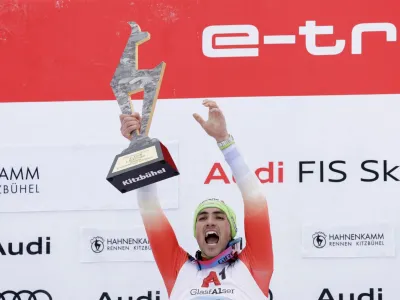 Alpine Skiing - FIS Alpine Ski World Cup - Men's Slalom - Kitzbuehel, Austria - January 22, 2023 Switzerland's Daniel Yule celebrates with the trophy on the podium after winning the men's slalom REUTERS/Leonhard Foeger