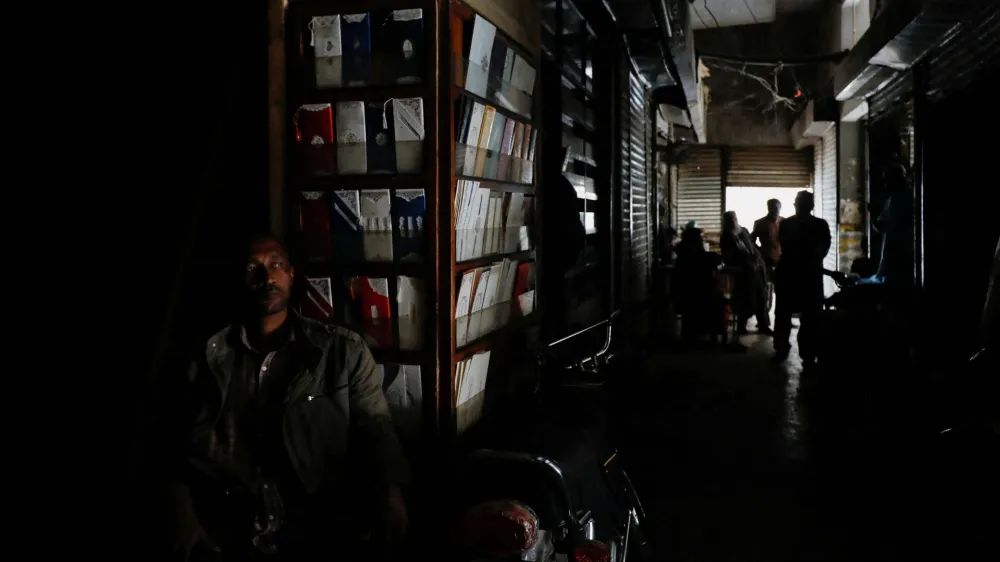 A man sits outside his shop during a country-wide power breakdown in Karachi, Pakistan January 23, 2023. REUTERS/Akhtar Soomro