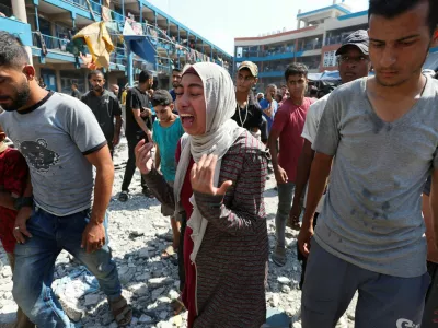 A Palestinian woman reacts at the site of an Israeli air strike on a UN school sheltering displaced people, amid the Israel-Hamas conflict, in Nusairat in central Gaza Strip, July 14, 2024. REUTERS/Ramadan Abed