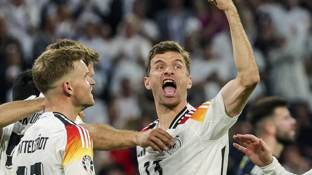 FILE - Germany's Thomas Mueller, right, celebrates during the Group A match between Germany and Scotland at the Euro 2024 soccer tournament in Munich, Germany, Friday, June 14, 2024. Germany forward Thomas Müller has announced his retirement from international soccer after a 14-year career that included the 2014 World Cup title. (Christian Charisius/dpa via AP, File)