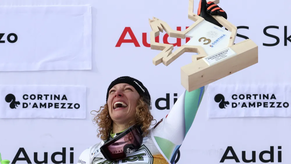 Slovenia's Ilka Stuhec celebrates on the podium after winning an alpine ski, women's World Cup downhill race, in Cortina d'Ampezzo, Italy, Saturday, Jan. 21, 2023. (AP Photo/Alessandro Trovati)