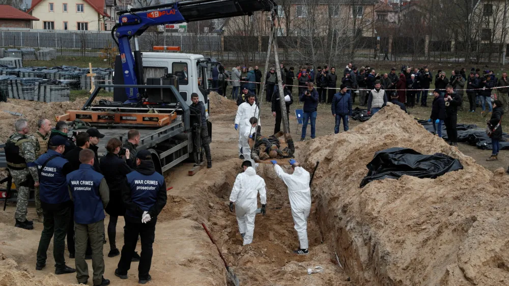 SENSITIVE MATERIAL. THIS IMAGE MAY OFFEND OR DISTURB Forensic technicians exhume the bodies of civilians who Ukrainian officials say were killed during Russia's invasion and then buried in a mass grave in the town of Bucha, outside Kyiv, Ukraine April 8, 2022. REUTERS/Valentyn Ogirenko   TPX IMAGES OF THE DAY