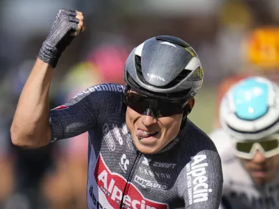 Belgium's Jasper Philipsen celebrates as he crosses the finish line ahead of Germany's Nikias Arndt, rear right, to win the sixteenth stage of the Tour de France cycling race over 188.6 kilometers (117.2 miles) with start in Gruissan and finish in Nimes, France, Tuesday, July 16, 2024. (AP Photo/Jerome Delay)