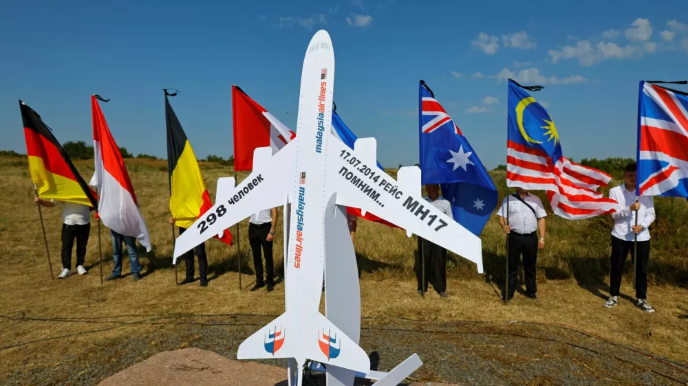 People hold flags at a memorial to victims of the Malaysia Airlines Flight MH17 plane crash during a ceremony marking the 10th anniversary of the accident, near the village of Hrabove (Grabovo) in the Donetsk region, Russian-controlled Ukraine, July 17, 2024. REUTERS/Alexander Ermochenko