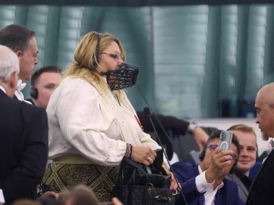 Diana Iovanovici-Sosoaca, European Parliament member and a far-right Romanian politician, wears a muzzle on her face as she is escorted out, before a vote to choose the next President of the European Commission, at the European Parliament in Strasbourg, France, July 18, 2024. REUTERS/Johanna Geron