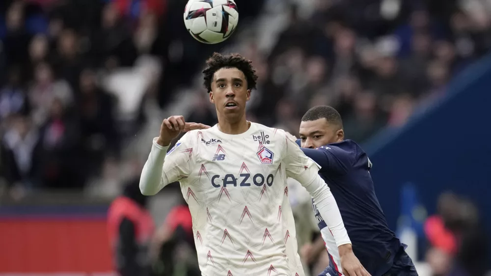 FILE - Lille's Leny Yoro controls the ball next to PSG's Kylian Mbappe, right, during the French League One soccer match between Paris Saint-Germain and Lille at the Parc des Princes stadium, in Paris, France, Sunday, Feb. 19, 2023. Manchester United completed the signing of 18-year-old defender Leny Yoro from Lille on Thursday, July 18, 2024. (AP Photo/Christophe Ena, File)