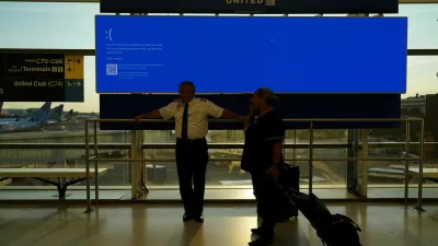 United Airlines employees wait by a departures monitor displaying a blue error screen, also known as the ?Blue Screen of Death? inside Terminal C in Newark International Airport, after United Airlines and other airlines grounded flights due to a worldwide tech outage caused by an update to Crowdstrike's "Falcon Sensor" software which crashed Microsoft Windows systems, in Newark, New Jersey, U.S., July 19, 2024. REUTERS/Bing Guan