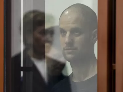 Wall Street Journal reporter Evan Gershkovich stands listening to the verdict in a glass cage of a courtroom inside the building of "Palace of justice," in Yekaterinburg, Russia, on Friday, July 19, 2024. A Russian court convicted Gershkovich on espionage charges that his employer and the U.S. have rejected as fabricated. He was sentenced to 16 years in prison after a secretive and rapid trial in the country's highly politicized legal system. (AP Photo/Dmitri Lovetsky)