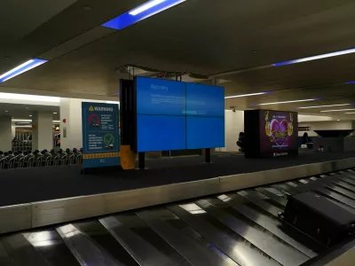 An item of checked luggage is seen near a monitor displaying a blue error screen, also known as the ?Blue Screen of Death? at a baggage claim area inside Terminal C in Newark International Airport, after United Airlines and other airlines grounded flights due to a worldwide tech outage caused by an update to Crowdstrike's "Falcon Sensor" software which crashed Microsoft Windows systems, in Newark, New Jersey, U.S., July 19, 2024. REUTERS/Bing Guan