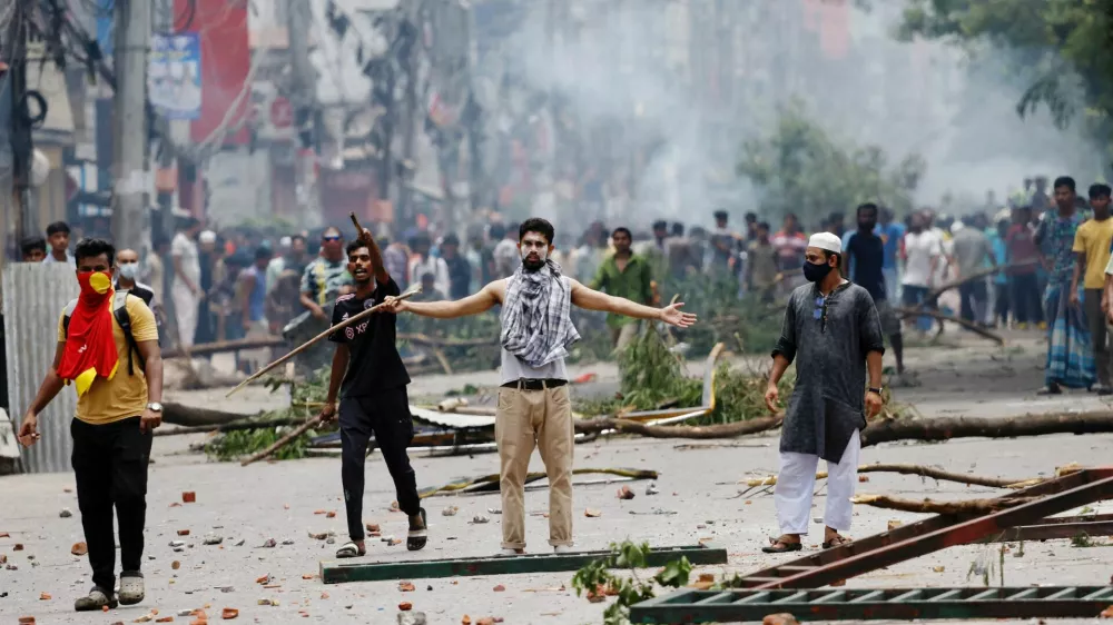 A demonstrator gestures as protesters clash with Border Guard Bangladesh (BGB) and the police outside the state-owned Bangladesh Television as violence erupts across the country after anti-quota protests by students, in Dhaka, Bangladesh, July 19, 2024. REUTERS/Mohammad Ponir Hossain   TPX IMAGES OF THE DAY